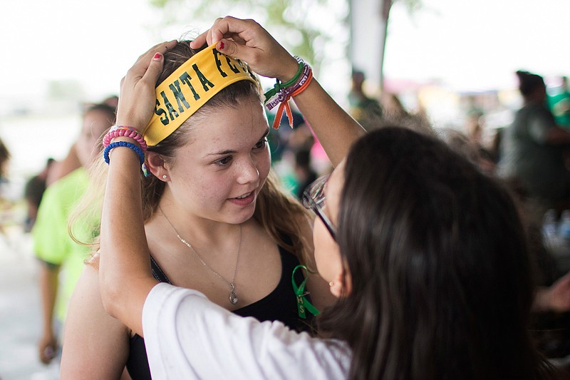 Diona Evers, right, helps her friend Sara Reul place a headband Sunday at the Santa Fe High School's Class of 2008 reunion fundraiser benefiting the victims of the Santa Fe school shooting on May 18.
