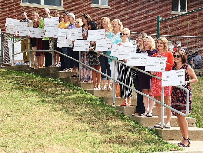 Representatives from the 19 agencies awarded grants from the United Way hold their oversized checks Tuesday.