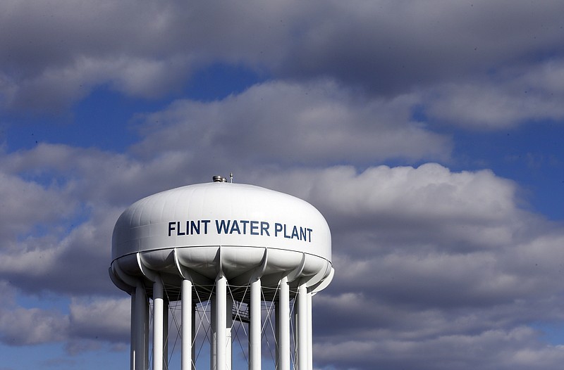 FILE - In this pMarch 21, 2016, file photo, the Flint Water Plant water tower is seen in Flint, Mich. A federal watchdog is calling on the U.S. Environmental Protection Agency to strengthen its oversight of state drinking water systems in the wake of the lead crisis in Flint, Michigan. In a report released July 19, 2018, the EPA’s Office of Inspector General says the agency must act now to be able to react more quickly in times of public-health emergencies.. (AP Photo/Carlos Osorio, File)