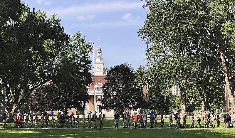 In this Monday, July 16, 2018 photo, students from the Corps of Cadets march in front of Jackman Hall, rear, on the campus of Norwich University in Northfield, Vt. Norwich has become the latest school to offer income share agreements, where colleges receive a percentage of the student's future salary, in place of some student loans. (AP Photo/David Jordan)