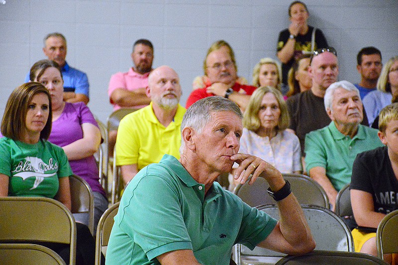 Members of the community listen Thursday as Blair Oaks Superintendent Jim Jones leads a public information meeting at Blair Oaks Elementary School regarding the possibility of a new high school before the board has to decide in August whether they want to raise the district's debt service levy without voter approval to get the process started earlier. 