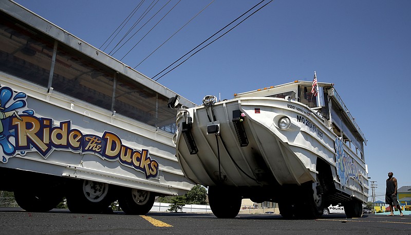 A man looks at an idled duck boat in the parking lot of Ride the Ducks Saturday, July 21, 2018 in Branson, Mo. One of the company's duck boats capsized Thursday night resulting in several deaths on Table Rock Lake. (AP Photo/Charlie Riedel)