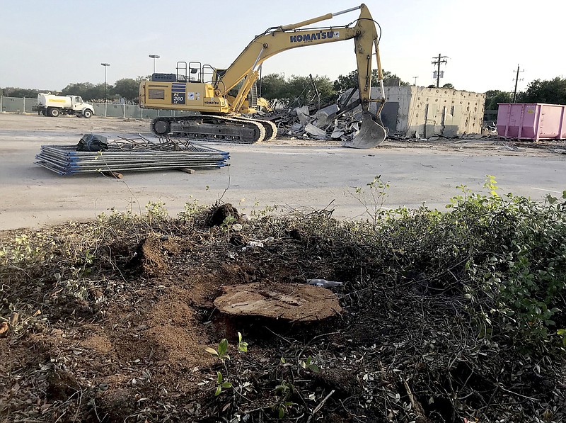 In this Tuesday, July 17, 2018 photo, only a stump remains from an oak tree stood in Houston, dedicated in 1961 to memorialize Texas Air National Guard Capt. Gary Herod, who sacrificed his life to save others in a jet crash that spring. Earlier this year, an arborist determined the tree was in decline. Believing the live oak would die, local real estate agent Charles Goforth has decided to build a longer-lasting memorial to Herod's heroism. (Alyson Ward/Houston Chronicle via AP)