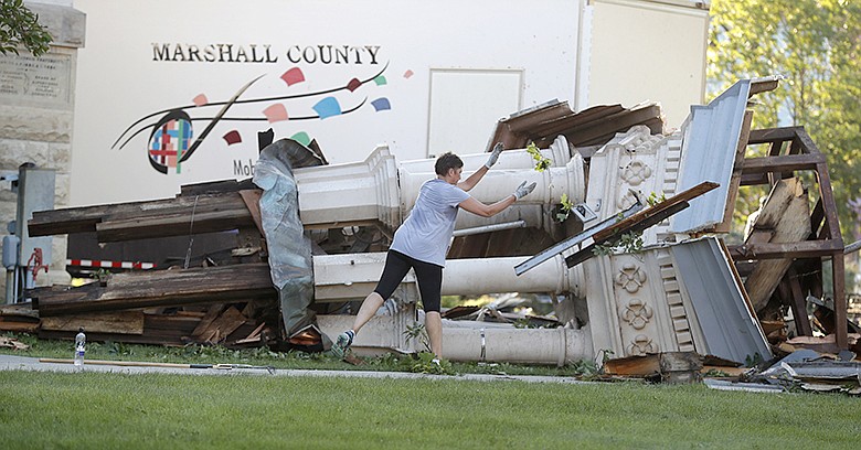 A worker cleans up debris from the tornado damaged Marshall County Courthouse's tower Thursday, July 19, 2018, in Marshalltown, Iowa. Several buildings were damaged by a tornado in the main business district in town including the historic courthouse
