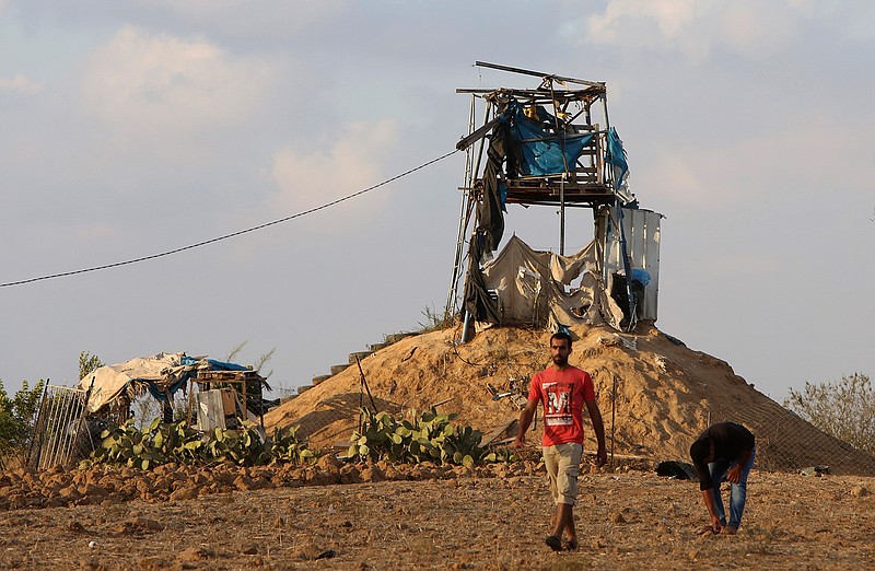 Palestinians inspect a military observation post that was hit by an Israeli tank shell east of Khan Younis, southern Gaza Strip, Friday, July 20, 2018. Israel pummeled Hamas targets in Gaza killing four Palestinians on Friday in a series of air strikes after gunmen shot at soldiers near the border, officials said. The Gaza Health Ministry said four Palestinians were killed. The militant Islamic Hamas that rules Gaza said three of the dead were members of the group. (AP Photo/Adel Hana)