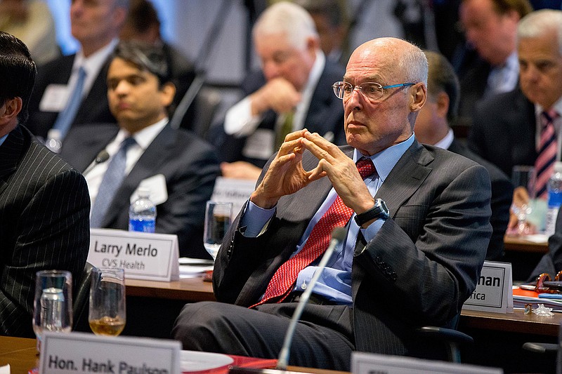 In this Sept. 16, 2015, file photo, former Treasury Secretary Henry Paulson listens as President Barack Obama speaks to business leaders at the quarterly meeting of the Business Roundtable in Washington to renew his calls for increased spending in infrastructure, education and scientific research. Three officials including Paulson who played vital roles in combating the 2008 financial crisis say they worry that the painful lessons from the banking system's near-collapse a decade ago may be forgotten. (AP Photo/Andrew Harnik, File)