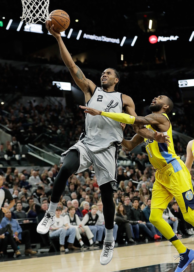  In this Jan. 13, 2018, file photo, San Antonio Spurs forward Kawhi Leonard (2) scores past Denver Nuggets guard Will Barton (5) during the second half of an NBA basketball game, in San Antonio. Two people familiar with the situation say San Antonio and Toronto have reached an agreement in principle on a trade that will send Kawhi Leonard to the Raptors and DeMar DeRozan to the Spurs. One of the people says the Spurs also are sending Danny Green to the Raptors as part of the deal. Both people spoke to The Associated Press on condition of anonymity Wednesday, July 18, 2018, because the deal has not been finalized. (AP Photo/Eric Gay, File)