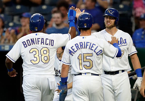 Hunter Dozier (right) congratulates Royals teammates teammates Jorge Bonifacio and Whit Merrifield after they scored on a single by Lucas Duda during the first inning of Friday night's game against the Twins at Kauffman Stadium.