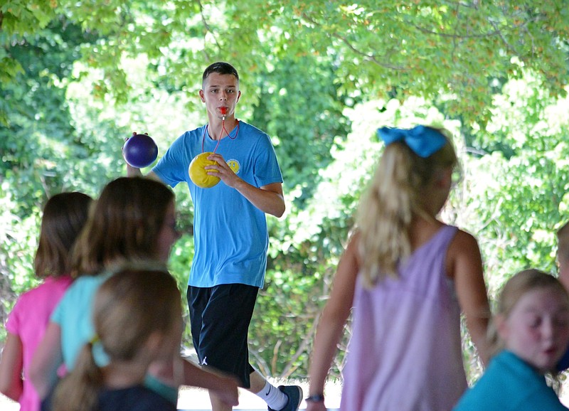 Chase Dickerson, a computer science major at Missouri State University in his second year as a camp counselor, plays dodge ball with children Tuesday July 10, 2018, during Camp Out and About at the Ellis-Porter Riverside Park pavilion. 