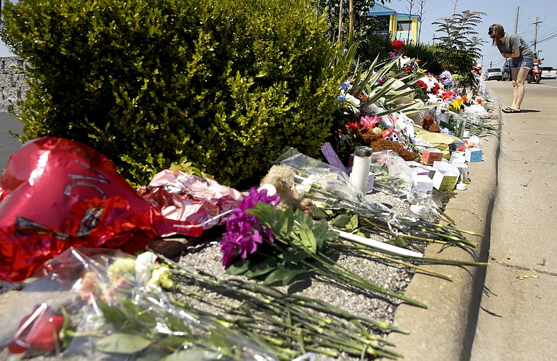 A woman looks at a memorial in front of Ride the Ducks Saturday, July 21, 2018 in Branson, Mo. One of the company's duck boats capsized Thursday night resulting in several deaths on Table Rock Lake. (AP Photo/Charlie Riedel)