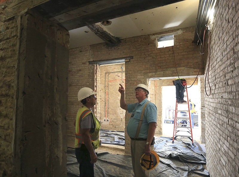 In this Friday, July 13, 2018 photo, Museum of South Texas History's Tom Fort, right, talks with construction foreman Pilo Garza about the progress of the renovation of the 1910 Hidalgo County Jail that sits on the museum grounds in Edinburg, Texas. The building is undergoing renovations after being closed since 2012. It is expected to reopen to the public in early 2019. (Nathan Lambrecht/The Monitor via AP)