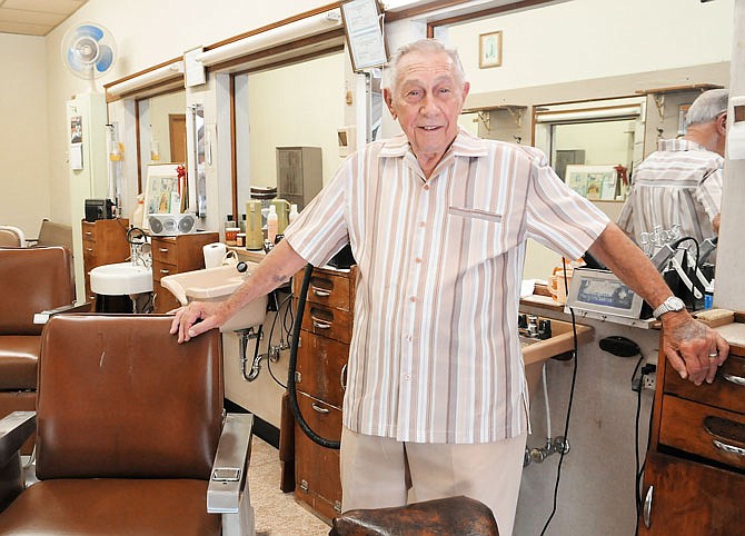 Larry Horstdaniel poses in 2014 in his Madison Street barber shop. Hortsdaniel, 90, recently announced he will close his shop after more than 64 years in business.