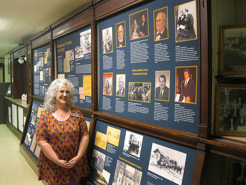 Melissa Nesbitt, archival manager for the Southwest Arkansas Regional Archives, stands near a display commemorating the archive collection's 40th anniversary.  The Hempstead County Historical Society took the lead in founding SARA in 1978. 