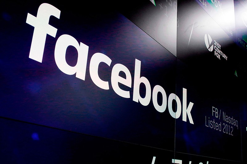 In this March 29, 2018, file photo, the logo for Facebook appears on screens at the Nasdaq MarketSite in New York's Times Square. Facebook's user base and revenue grew more slowly than expected in the second quarter of 2018 as the company grappled with privacy issues, sending its stock tumbling after hours. (AP Photo/Richard Drew, File)