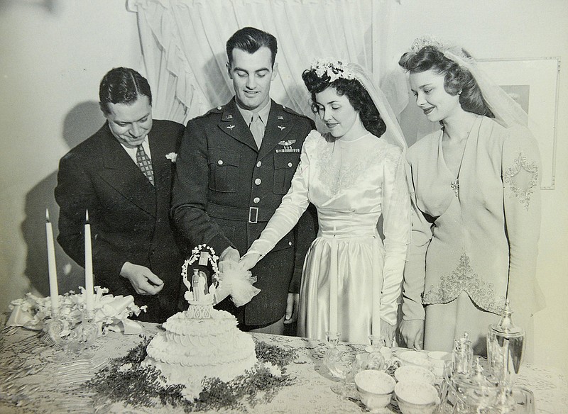 Bettye DeYoung, right center, is shown cutting her wedding cake with her husband Art DeYoung in 1941 while wearing the same wedding dress that would later be worn by her daughter-in-law Ofelia DeYoung and her granddaughter Jennifer Kramer at their weddings, 36 years apart.  (Courtesy photo)