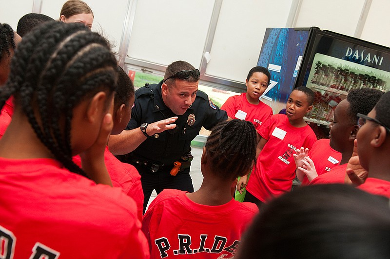 A Texarkana, Ark., police officer works with students on a team-building exercise during the opening of 2016 P.R.I.D.E. Academy at College Hill Middle School. (Staff file photo by Jerry Habraken)
