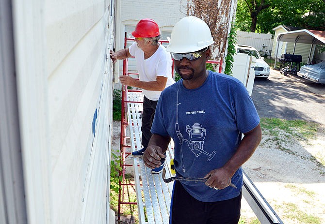 Tony Triplett, foreground, and Clyde Powers work on the second floor exterior of a Habitat for Humanity home Saturday morning at 412 E. Ashley St.