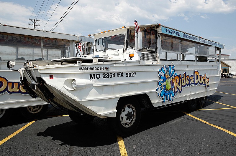 A duck boat sits idle July 20 in the parking lot of Ride the Ducks, an amphibious tour operator in Branson, Mo. A lawsuit seeking $100 million in damages was filed Sunday, July 29, against the owners and operators of a duck boat that sank July 19. 
