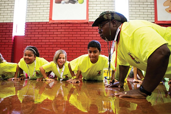 Officer Alvin Howard does pushups with team yellow Monday during P.R.I.D.E. Academy at College Hill Middle School in Texarkana, Ark. The academy is a five-day camp for sixth-graders that provides the tools for students to make smart life choices.