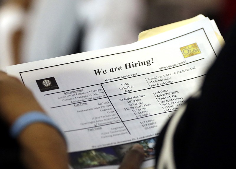 FILE In this June 21, 2018 file photo, a job applicant looks at job listings for the Riverside Hotel at a job fair hosted by Job News South Florida, in Sunrise, Fla.    Economists forecast that employers added 191,000 jobs in July, down from 213,000 in June but easily enough to lower the unemployment rate over time. The jobless rate is projected to decline to 3.9 percent, near an 18-year low, from 4 percent. The Labor Department’s monthly jobs report will be released at 8:30 a.m. Eastern Friday, Aug. 3. (AP Photo/Lynne Sladky)