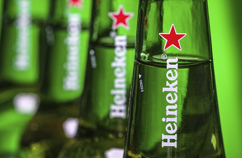 FILE - In this file photo dated Friday, March 30, 2018, bottles of Heineken beer are photographed in Washington, USA.  Dutch brewing company Heineken said in a statement Friday Aug, 3, 2018, it is buying a 40 percent stake in the company that controls China’s biggest beer maker, China Resources Beer.(AP Photo/J. David Ake, FILE)