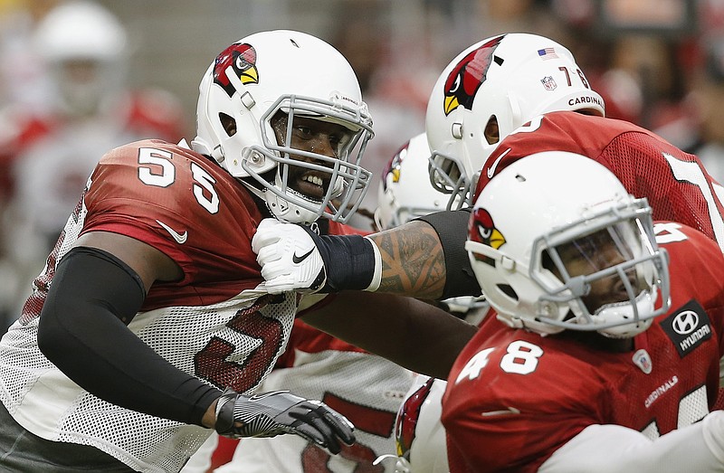 Arizona Cardinals defensive end Chandler Jones (55) tries to break away from offensive guard Mike Iupati, back right, as running back Derrick Coleman (48) makes a block during an NFL football practice Saturday, Aug. 4, 2018, in Glendale, Ariz. (AP Photo/Ross D. Franklin)