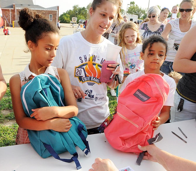 2018 FILE: Church members hand out 552 backpacks full of school supplies to community members who were served on a first-come first-serve basis. 