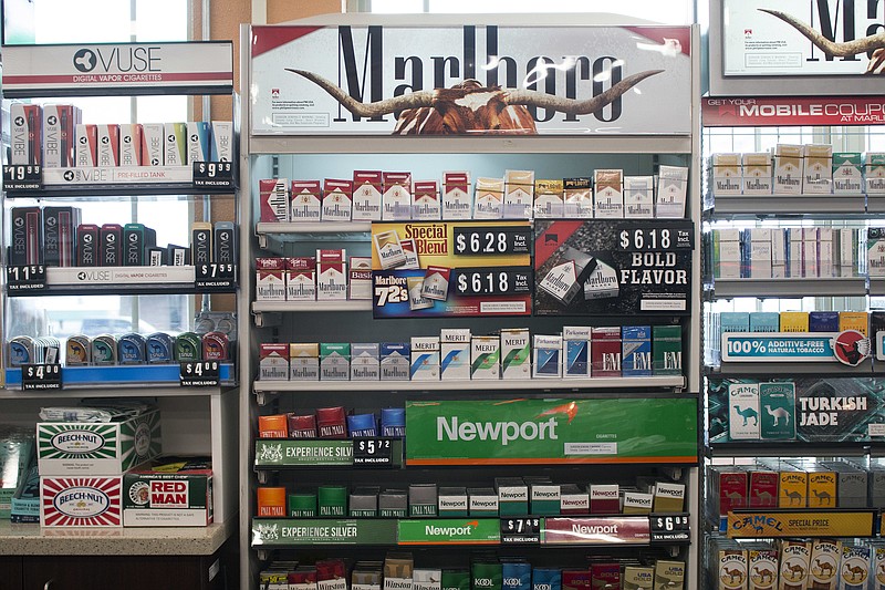 FILE - In this May 18, 2017 file photo, packs of cigarettes are offered for sale at a convenience store in Helena, Mont. (AP Photo/Bobby Caina Calvan, File)