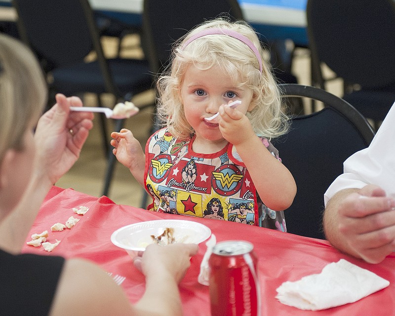 Samantha Hackman, 2, enjoys eating her ice cream during the Council for Drug Free Youth Ice Cream Social event in August 2018. Samantha helped her mother and father finish their bowls of ice cream.