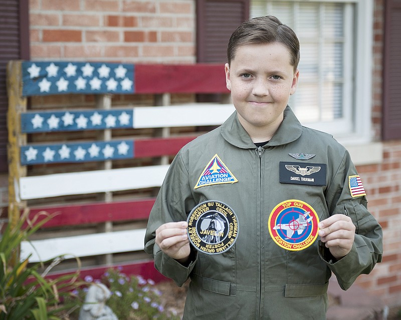 Daniel Thurman stands in front of his house Monday in Jefferson City, while wearing his uniform from participating in the Aviation Challenge Mach I at the U.S. Space and Rocket Center in Huntsville, Alabama. Thurman attended the week-long program and received recognition for being one of the top three participants to earn the most points in flight simulator exercises as noted by the Top Gun patch, as well as being a member of the team with the most points earned by working through scenario based missions, as noted by the Team Javelin patch held in his right hand.
