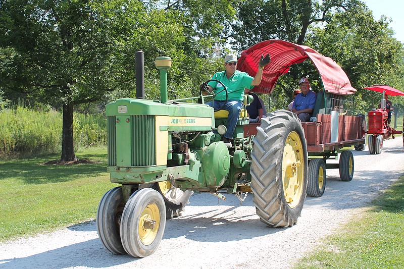 <p>Submitted</p><p>Greg Buckman, of Hallsville, rides his vintage John Deere during the 2017 Callaway Vintage Tractor Drive while Lewis Baumgartner, who started the fundraiser, looks out from the trailer.</p>