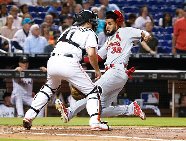 Jose Martinez of the Cardinals slides in to score as Marlins catcher J.T. Realmuto waits for the throw after a double by Marcell Ozuna in the sixth inning of Wednesday's game in Miami.