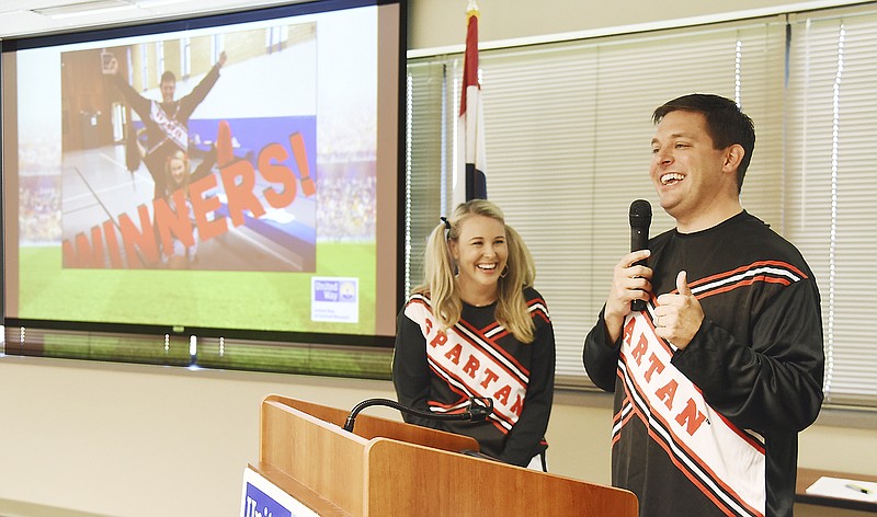 Ryan Freeman and Missy Dunn, co-chairs of this year's United Way campaign, react to the photo on the screen to their right during Thursday's United Way of Central Missouri's appreciation breakfast. The annual breakfast is to thank community campaign businesses, campaign leadership and the media for previous work and in advance for the work and volunteers involved in the current fundraising campaign. This year's theme is sports.