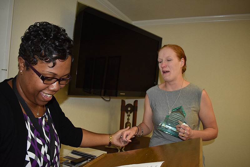 Salena Pruitt, who is blind, is led to the podium by Angela Gray, left, at noon Friday to receive an award. Gray represents the Arkansas Department of Human Services' Division of Services for the Blind. Salena is a Realtor for CENTURY 21 and was honored for her determination to overcome adversity and succeed in her work.