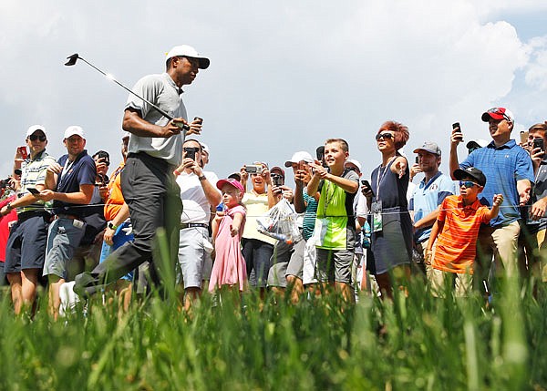 Tiger Woods walks past spectators on his way to the eighth tee during Friday's second round of the PGA Championship at Bellerive Country Club in St. Louis.