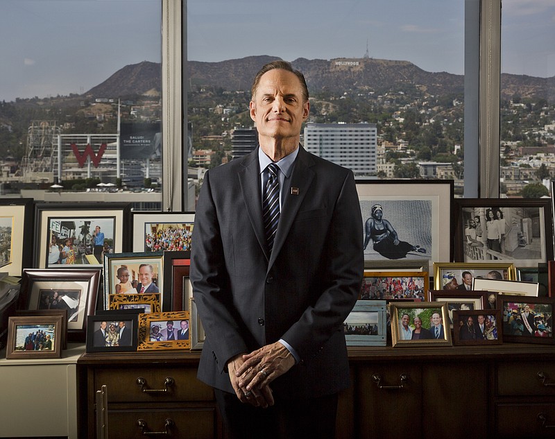 In this Monday, July 30, 2018, photo Michael Weinstein, president of the AIDS Healthcare Foundation poses for a photo of his office overlooking the Hollywood Hills in Los Angeles. The AIDS Healthcare Foundation and Alliance of Californians for Community Empowerment Action are sponsoring a measure known as Proposition 10. The measure would let cities and counties regulate rental fees in buildings current state law shields from such control. (AP Photo/Damian Dovarganes)