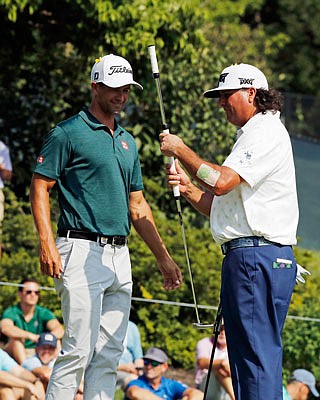 Adam Scott (left) and Pat Perez look at the putter Scott uses during Saturday's third round of the PGA Championship at Bellerive Country Club in St. Louis.