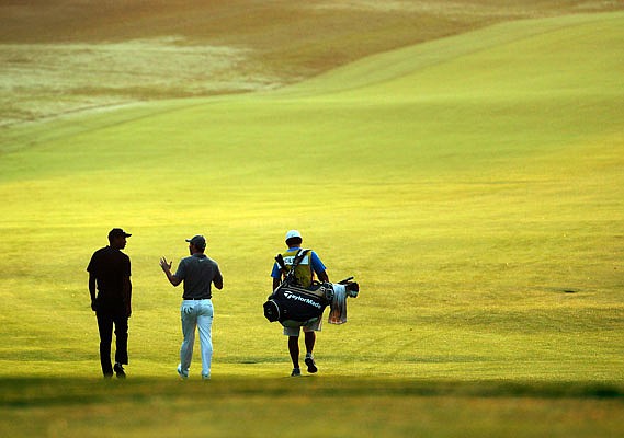 (From left) Tiger Woods, Rory McIlroy and caddie Harry Diamond walk out to the course Saturday morning to resume the second round of the PGA Championship at Bellerive Country Club in St. Louis.