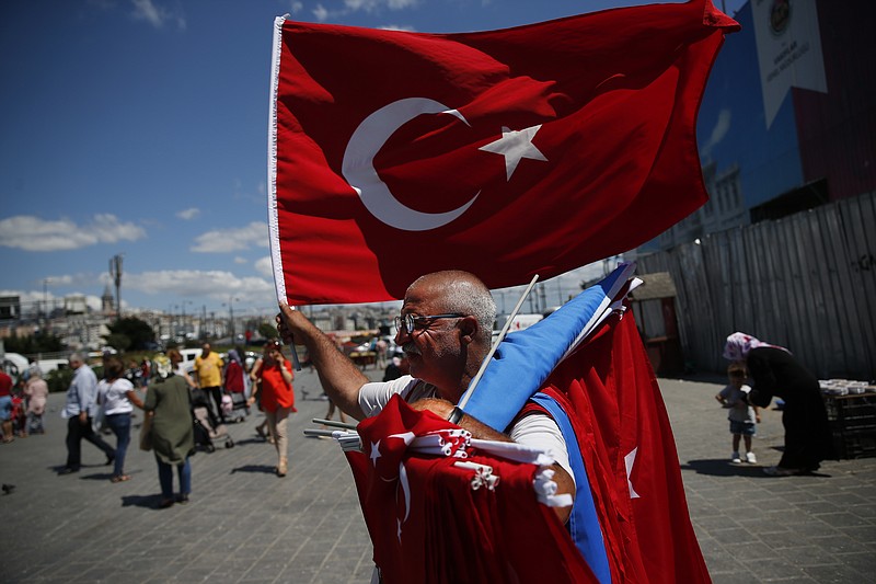 A vendor offers Turkish flags for sale at a market in Istanbul, Monday, Aug. 13, 2018. Turkey's central bank announced a series of measures on Monday to free up cash for banks as the country grapples with a currency crisis sparked by concerns over President Recep Tayyip Erdogan's economic policies and a trade and diplomatic dispute with the United States. (AP Photo/Lefteris Pitarakis)