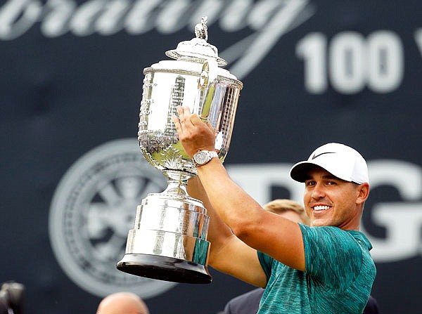 Brooks Koepka lifts the Wanamaker Trophy after winning the PGA Championship on Sunday at Bellerive Country Club in St. Louis.