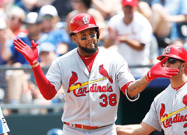 Jose Martinez of the Cardinals reacts after hitting an RBI single as first-base coach Oliver Marmol looks on in the third inning of Sunday afternoon's game against the Royals at Kauffman Stadium.