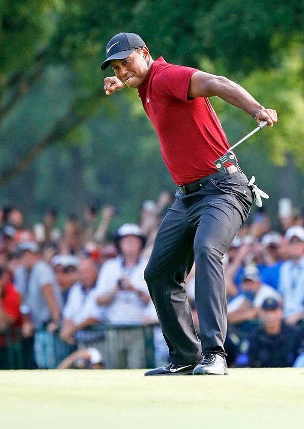 Tiger Woods celebrates his birdie putt on the 18th green during Sunday's final round of the PGA Championship at Bellerive Country Club in St. Louis.