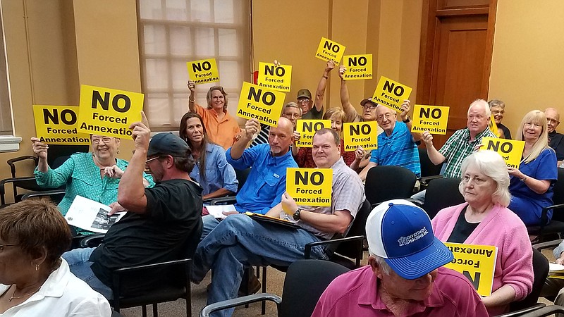 Bowie County residents against annexation of their land into the Texarkana, Texas, city limits hold up protest signs before a City Council meeting Aug. 13, 2018, at City Hall.