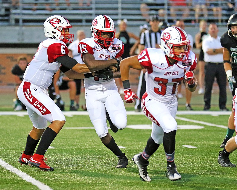 Jays quarterback Devin Roberson fakes a handoff to running back Maleek Jackson during a game last season against Rock Bridge in Columbia. 