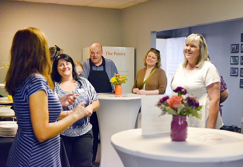 Director Kolbi Ward speaks to guests Monday during an open house at The Pantry. The Pantry recently relocated to 3702 W. Truman Blvd., Suite 122.