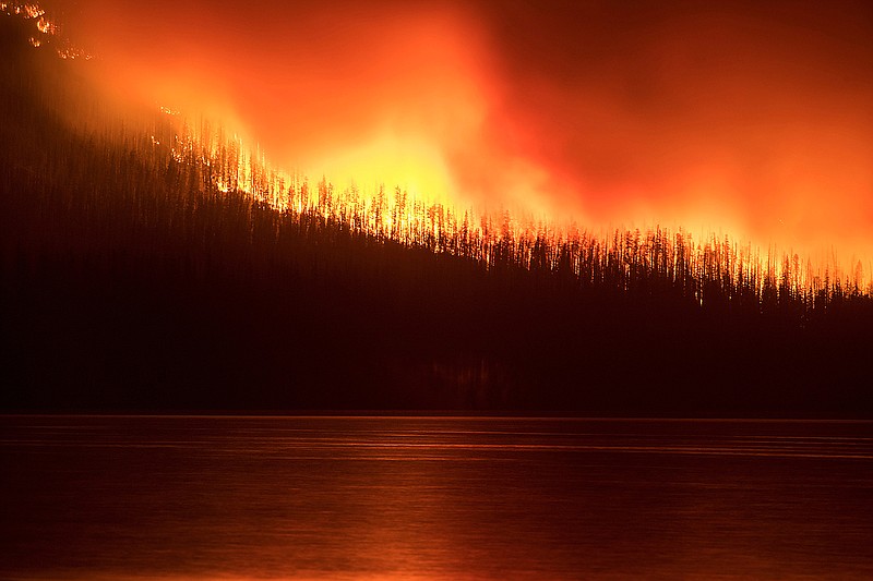In this photo taken Sunday a fire burns next to Lake McDonald in Glacier National Park in northwest Montana. The fire, which was started by lightning on  Saturday night, has forced the evacuation of the Lake McDonald Lodge and a nearby campground.