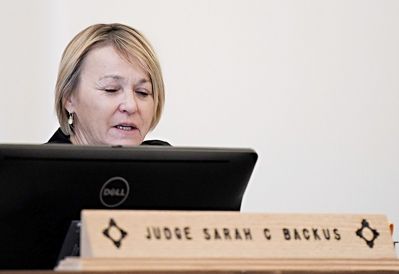 In this Monday, Aug. 13, 2018 photo, District Court Judge Sarah C. Backus presides over the hearing in the Amalia, N.M., desert compound case in Taos, N.M. Backus cleared the way for the release of two men and three women under conditions of house arrest including ankle monitors, despite assertions by prosecutors that the group was training children to use firearms for an anti-government mission and should remain in jail pending trial. Backus' decision to allow the release of an extended family accused of child abuse at a ramshackle desert compound set off a political uproar. (Roberto E. Rosales/The Albuquerque Journal via AP)