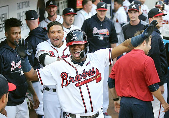 Ronald Acuna Jr. celebrates with teammates in the Braves dugout after hitting a lead-off home run in Tuesday night's game against the Marlins in Atlanta.