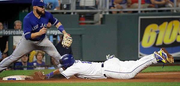 Salvador Perez of the Royals beats the tag by Blue Jays third baseman Russell Martin to advance  on a fly out by Jorge Bonifacio during the third inning of Tuesday night's game at Kauffman Stadium.