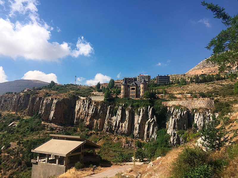 In this Friday, July 27, 2018 photo, mountains surround Faraya, a popular ski resort north of the capital Beirut, Lebanon. Whether it's war or peace, Lebanon's high mountain ranges have long been a favorite refuge for the Lebanese living in the cities, towns and villages below and along the Mediterranean coastline. The Lebanese drive up the mountains to avoid the summer's heat or, for those with deep pockets, to ski in winter. (AP photo/Hamza Hendawi)